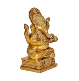 Brass Ganesh idol statue, side view, seated posture with raised hands and ornate base