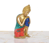 Brass Buddha idol sitting, profile view, blue robe with red base and teal back panel