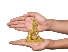 Brass Laddu Gopal idol statue on round base, shown for size in hands