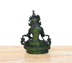 Hinteransicht: grüne Tara Devi Statue im Meditationssitz auf rundem Sockel