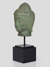 Bronze Buddha head idol on black stand, side profile view