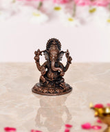 Copper Lord Ganesha idol, 2-inch seated figure with four arms and detailed crown