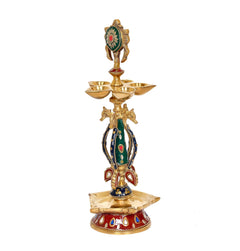 Brass chakra oil lamp diya with painted green-red deity, flared top bowls and round base
