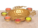Gold peacock decorative urli bowl with tealights around the rim