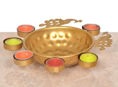 Gold peacock decorative urli bowl with tealights around the rim