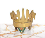 Brass diya lamp rear view with teal triangular panel and chakra-style prongs