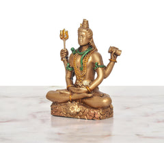Four-armed Shiva idol sitting cross-legged, gold resin with green details and trident