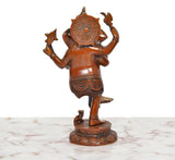 Brass dancing Ganesha idol from rear, circular halo detail, four arms raised