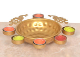 Gold decorative urli bowl with 6 tealights in red and green colors