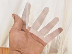 Hand holding a transparent wrapping sheet, showing its sheer flexibility