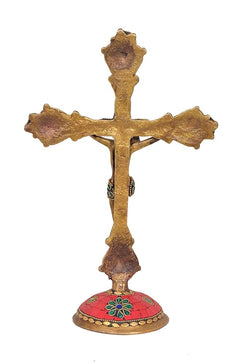 Back view brass Jesus cross sculpture with red round base and ornate pedestal