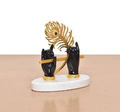 Black resin Krishna hands and flute, gold peacock hood, white round base, gold accents