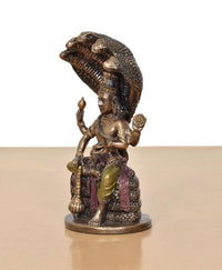 Side view of Vishnu resin statue seated on Sheshnag, detailed serpent hood