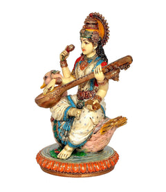 Resin Saraswati idol side view, red and blue dress, veena in hands