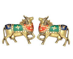 Brass Kamdhenu-style cow pair wall hanging, two standing cows with red-green-blue paint