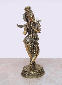 Brass Krishna idol playing flute, side view with jeweled headdress and pedestal