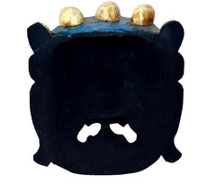 Back of wall mask with dark surface and gold-capped head details along the top