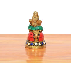 Brass Ganesha statue back view, conch-holding pose with multicolor accents