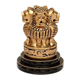 Gold-toned carved lion Ashoka Stambh emblem memento on black pedestal, close-up