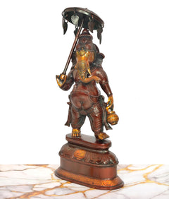 Ganesha with parasol in one hand, side view of multicolored brass figurine