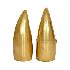 Back view of two brass cone idols, smooth golden surfaces with carved base edges