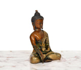 Three-quarter view: multicolor brass Buddha statue seated, hand in Varada mudra