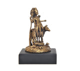 Gold-tone panchaloha deity idol on black base, angled side view