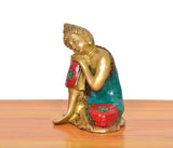 Messing-Buddha im Seitenprofil, goldfarben mit türkis-rotem Mosaikgewand
