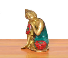 Messing-Buddha im Seitenprofil, goldfarben mit türkis-rotem Mosaikgewand