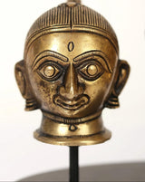 Close-up brass Gauri/Parvati head face with crown and bindi on dark base