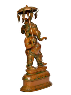 Brass Ganesha statue with parasol, side/back view, decorative hanging ornaments