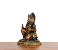 Brass Hanuman JI sitting idol from side angle, ornate crown and patterned torso, on base