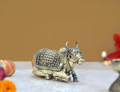 Brass Nandi bull statue with side profile, detailed saddle and decorative swirls