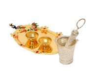 Decorated oval plate with two gold bowls, brass pichkari, and silver cup with handle
