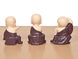 Purple resin monk Buddha figurines from the back, seated, hands at sides