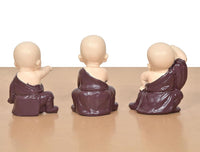Purple resin monk Buddha figurines from the back, seated, hands at sides