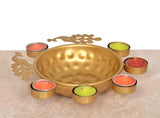 Gold decorative urli with peacock cutout sides and six tea light holders