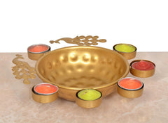 Gold decorative urli with peacock cutout sides and six tea light holders