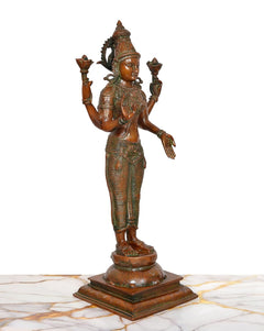 Brass Lakshmi murti in side profile, raised hands with lotuses, carved pedestal base