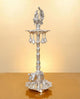 Silver metal peacock oil lamp stand with ornate legs and multi-tier bowl