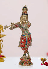 Brass Krishna flute idol statue, gold face, red-and-green jeweled outfit, standing