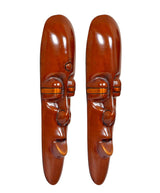 Copper-brown tribal face plaques, angled view with forehead, eyes, and mouth details