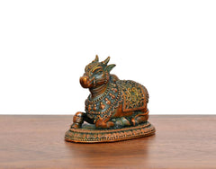 Seated Nandi brass figurine with teal, gold, and red decorative patterns
