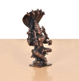 Side view of copper goddess idol statue, seated posture with cobra-hood canopy