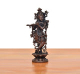 Copper Krishna playing flute murti, side profile with arm extended and ornate jewelry.