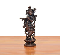 Copper Krishna playing flute murti, side profile with arm extended and ornate jewelry.