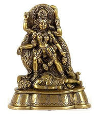 Brass Kali Maa idol seated, ornate detailing, with devotees/figures and lion at base.