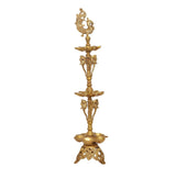 Golden brass diya stand with peacock crest and three stacked bowls for oil lamps