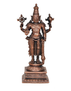 Copper Vishnu idol standing, front view with discus wheel and raised hands on pedestal