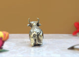 Brass Nandi bull statue with upward horns, small figurine from behind, centered